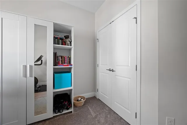 a view of an empty room with closet and a window