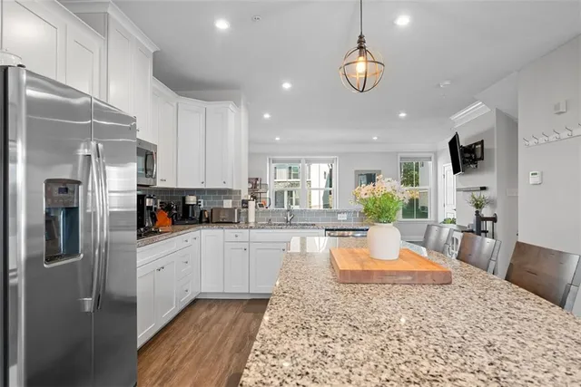 a large white kitchen with lots of counter top space appliances and cabinets