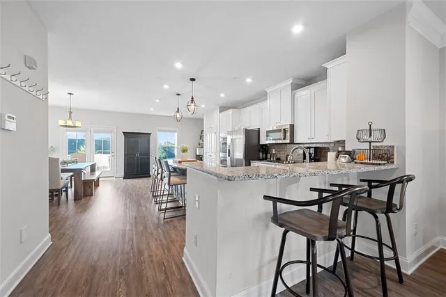 a kitchen with stainless steel appliances a table and chairs in it