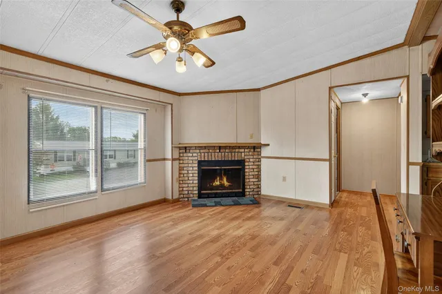a view of empty room with wooden floor and fireplace