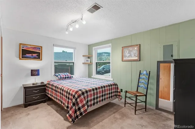 a bedroom with a bed table and a window