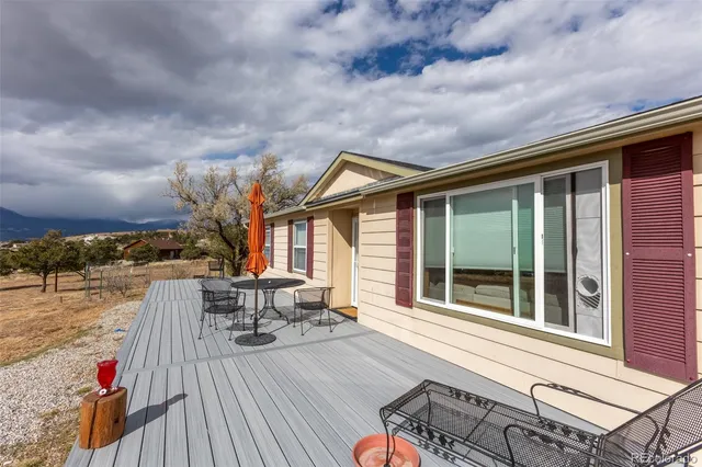a roof deck with table and chairs and wooden floor