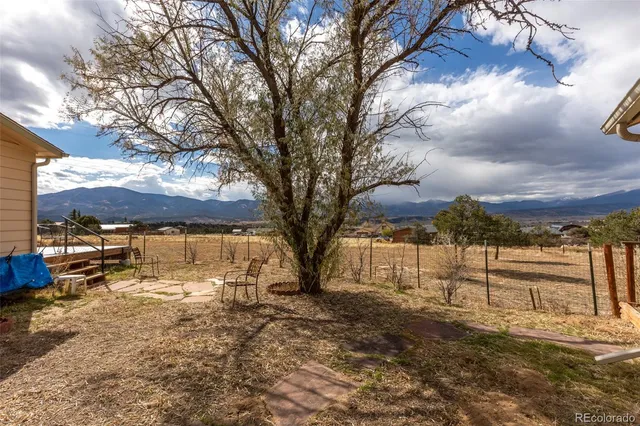 a view of a house with a yard and wooden fence