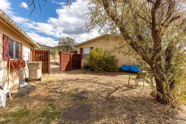a backyard of a house with table and chairs