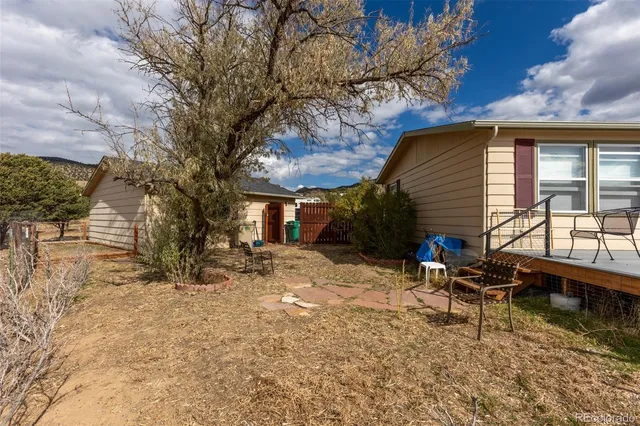 an aerial view of a house with a yard and mountain view in back