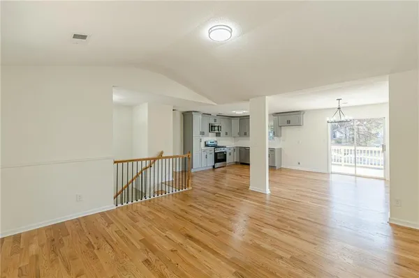 a kitchen with stainless steel appliances granite countertop a sink cabinets and wooden floor