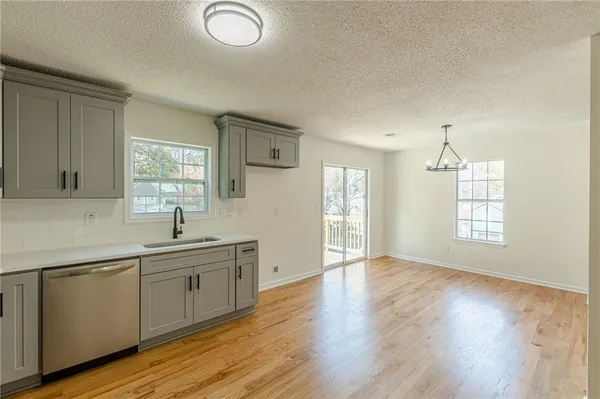 a view of a big room with windows and chandelier fan
