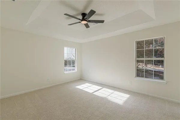 an empty room with a window and mirror fan