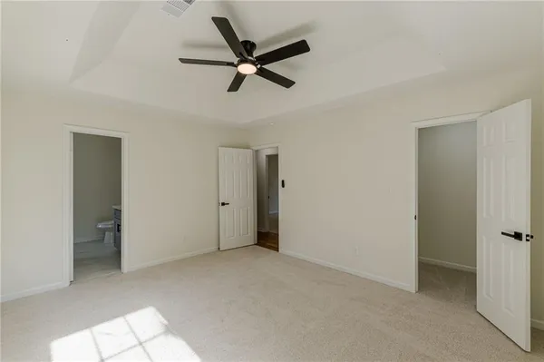 a view of an empty room with a window and closet area