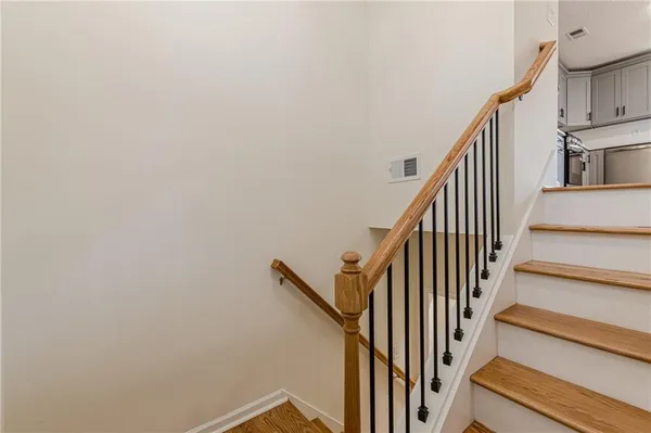 a view of staircase with wooden floor and white walls
