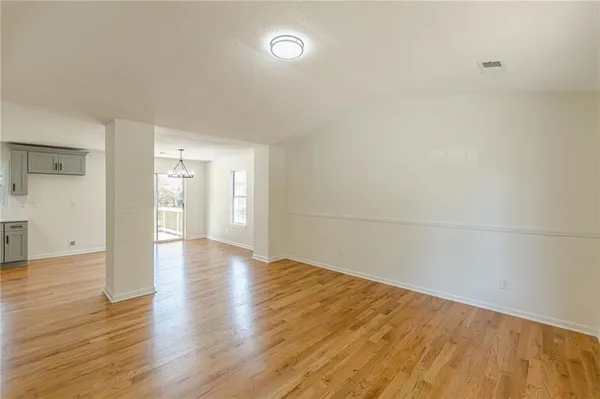 a view of a hallway with wooden floor and chandelier
