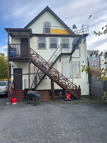 a view of a house with a yard and a wooden deck