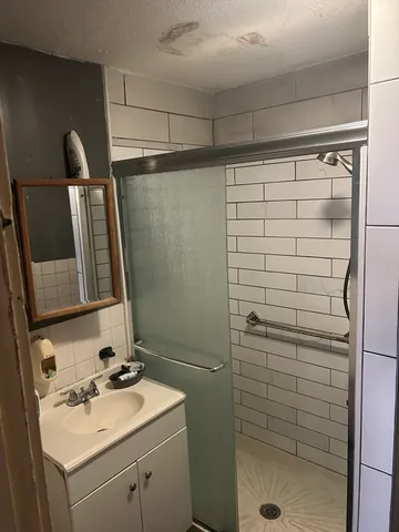 a bedroom with a bed and dresser with mirror