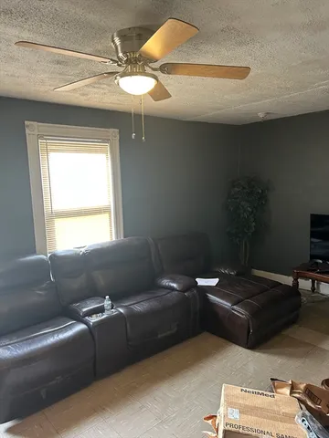 an empty room with windows and fan
