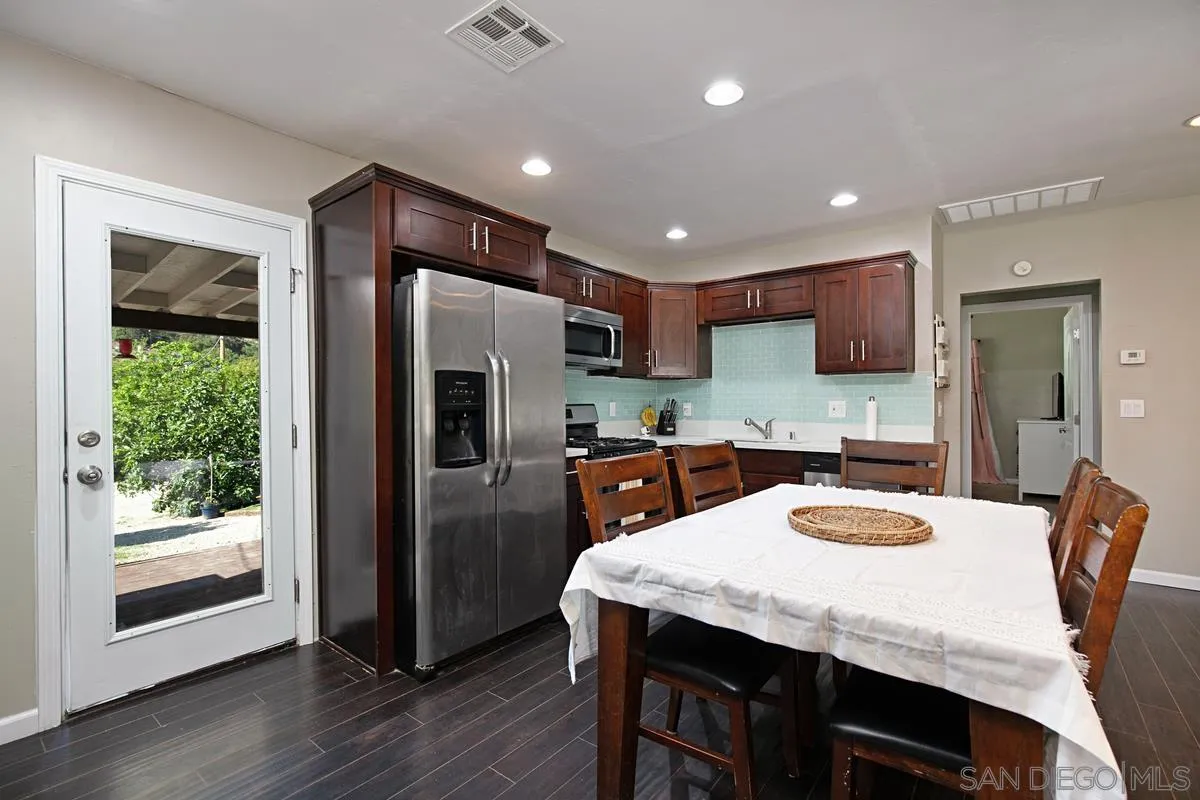 10390 Del Rio Road Spring Valley, CA 91978 - Photo 8 of 38 a kitchen with refrigerator a sink and chairs