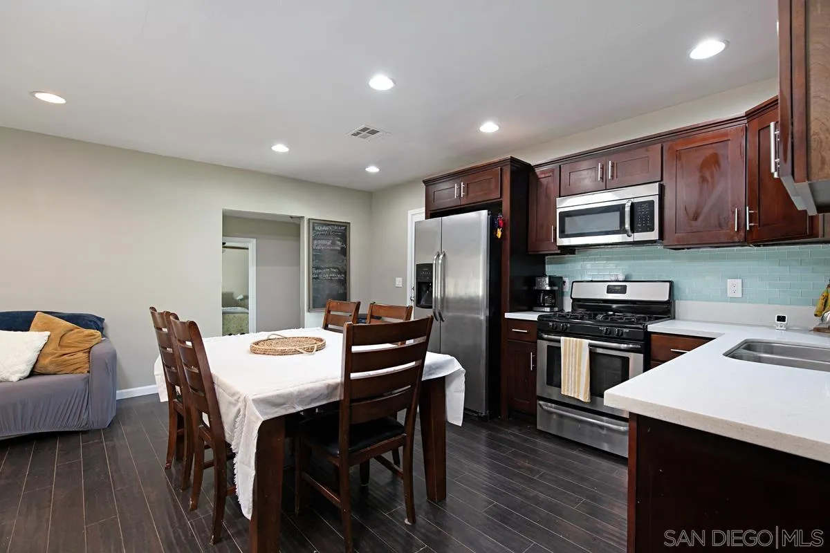 10390 Del Rio Road Spring Valley, CA 91978 - Photo 10 of 38 a kitchen with a table chairs refrigerator and microwave