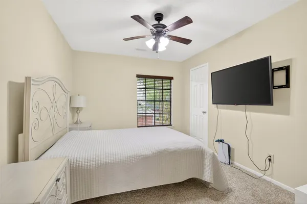a bedroom with a bed tv and a window