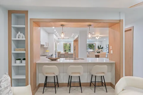 a kitchen with granite countertop a stove a sink and a refrigerator