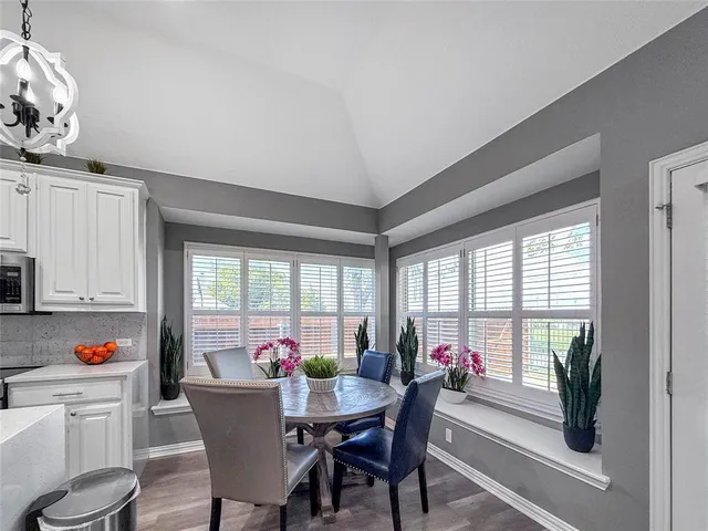 a view of a dining room with furniture a chandelier and wooden floor