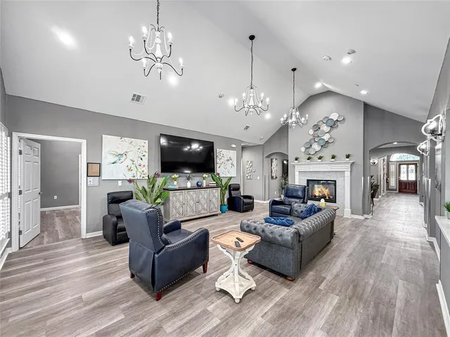 a living room with furniture a chandelier and a fireplace