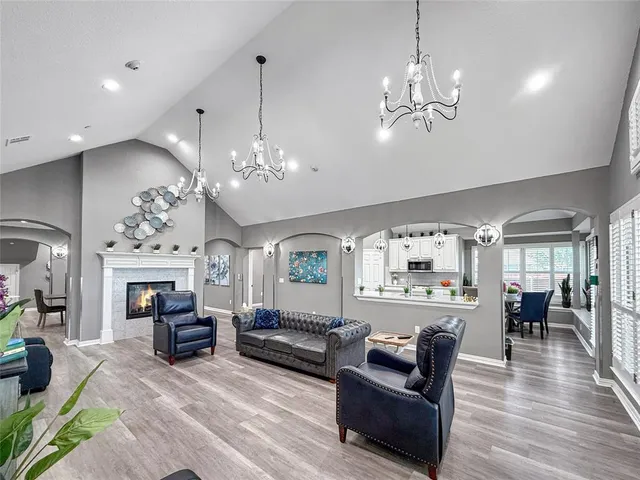 a living room with furniture a chandelier a fireplace and a chandelier