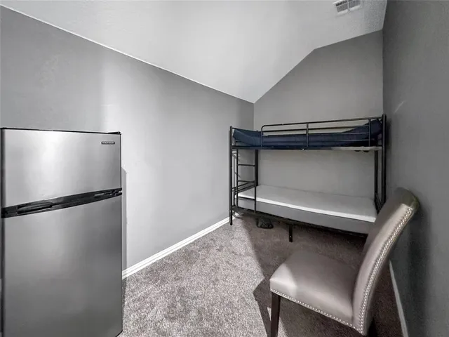 a view of cabinets with stainless steel appliances wooden floor and living room