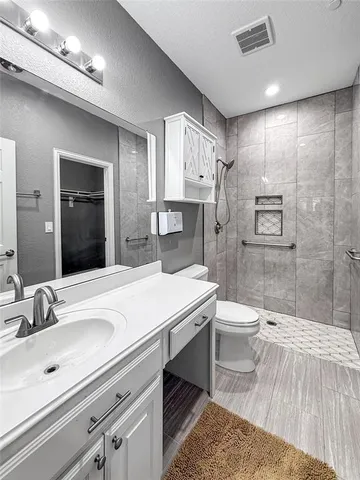 a bathroom with a sink a toilet and shower