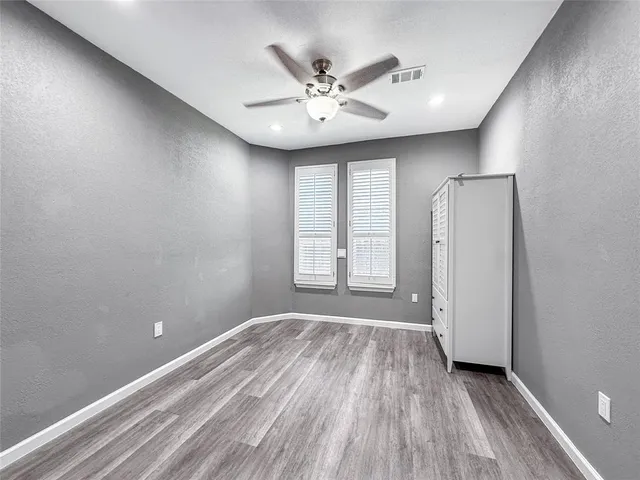 a view of a livingroom with a ceiling fan and wooden floor