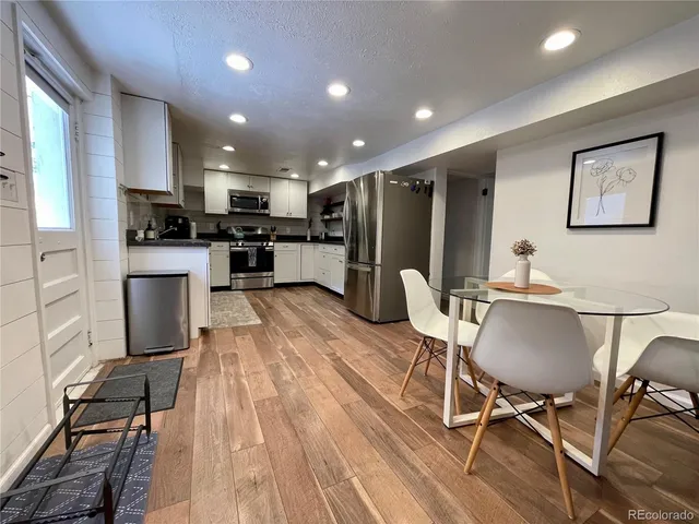 a living room with stainless steel appliances kitchen island granite countertop furniture wooden floor and a view of kitchen