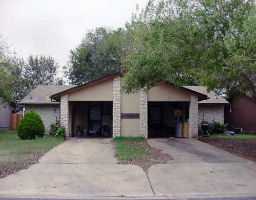 a view of a wooden house with a yard and large tree