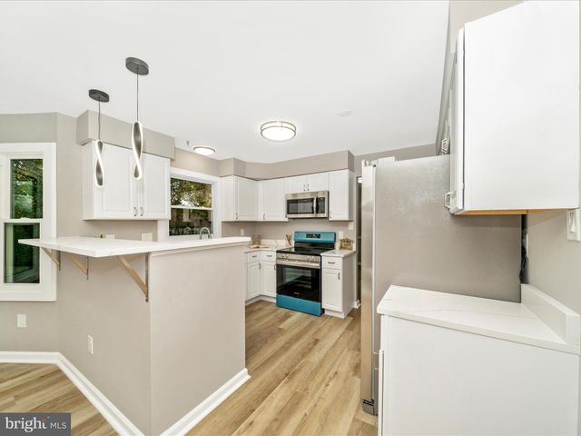 a kitchen with granite countertop a stove microwave and refrigerator