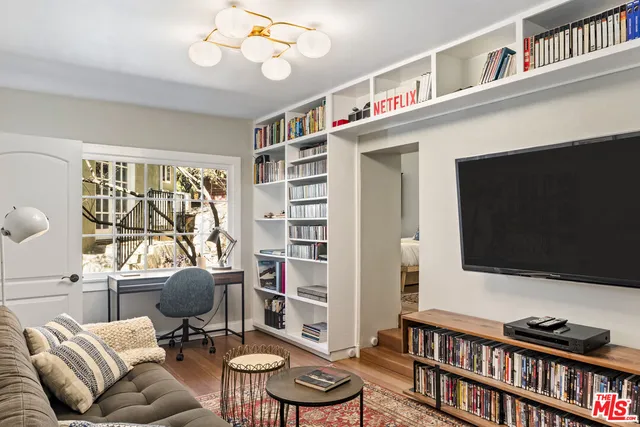 a living room with furniture a flat screen tv and a bookshelf