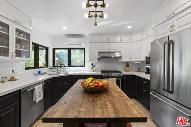 a kitchen with a sink a stove a refrigerator cabinets and a window