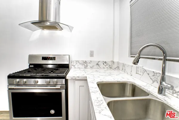 a kitchen with a stove a sink and a microwave