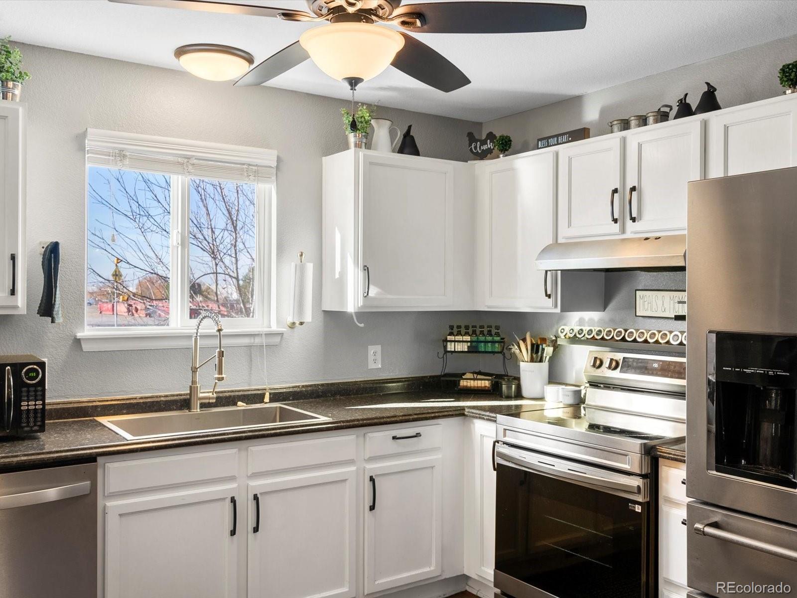 9657 Ironton Street Commerce City, CO 80022 - Photo 13 of 48 a kitchen with stainless steel appliances granite countertop a sink a stove and a refrigerator