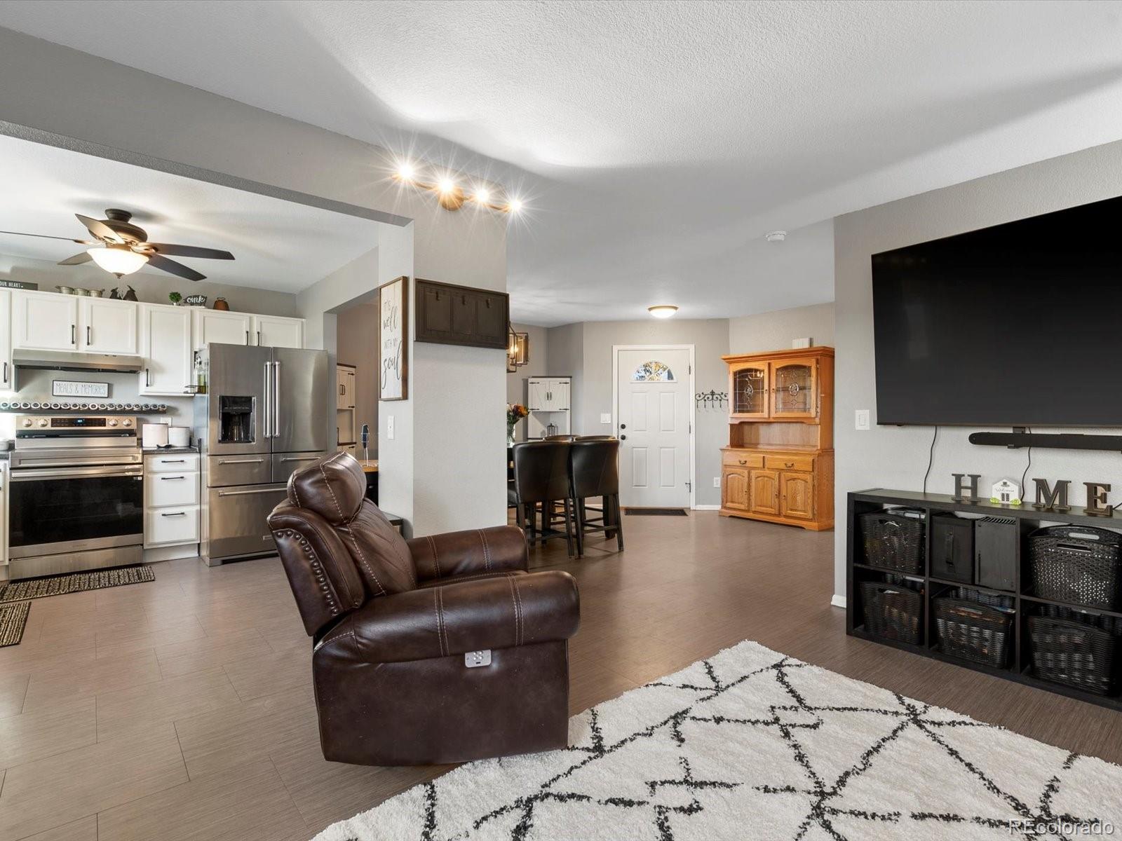 9657 Ironton Street Commerce City, CO 80022 - Photo 19 of 48 a living room with furniture and a flat screen tv