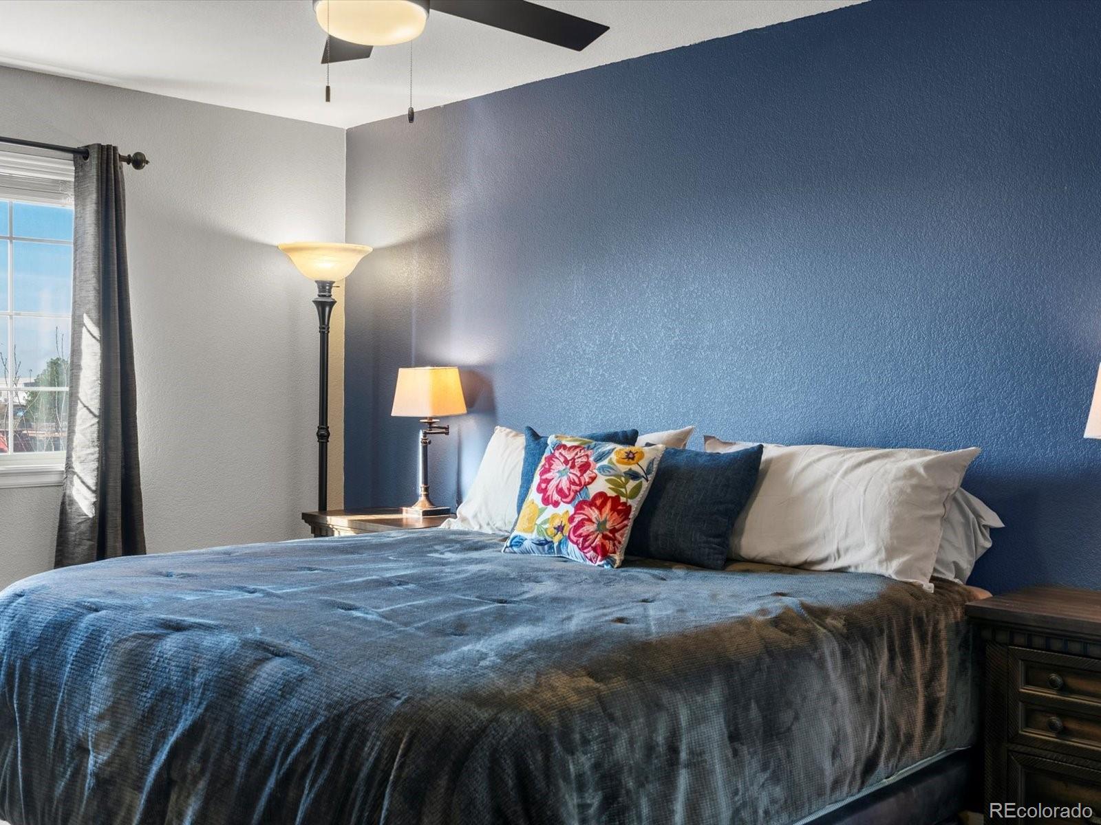 9657 Ironton Street Commerce City, CO 80022 - Photo 24 of 48 a bedroom with a bed and a lamp