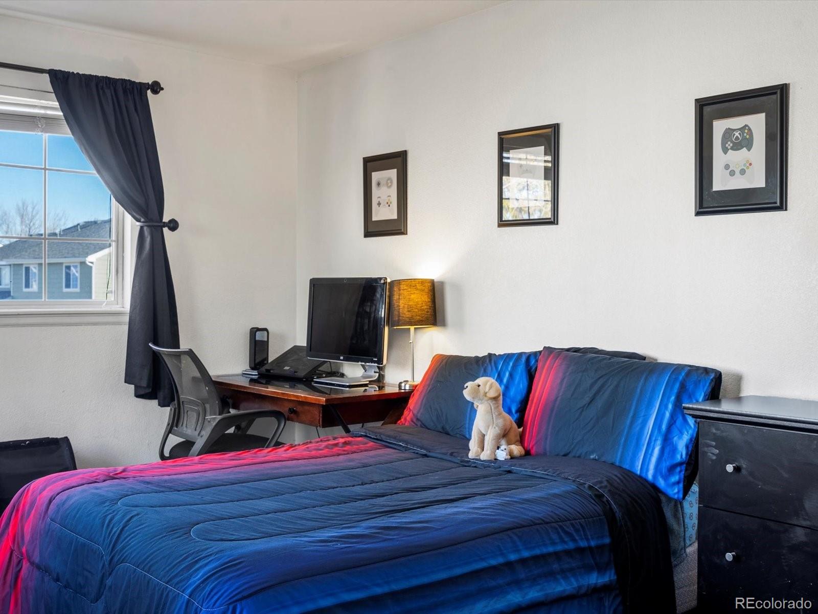 9657 Ironton Street Commerce City, CO 80022 - Photo 29 of 48 a bedroom with a bed and wooden floor