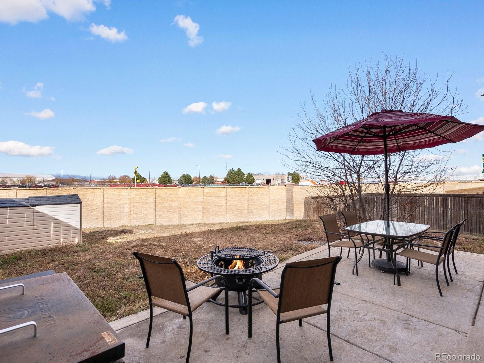 9657 Ironton Street Commerce City, CO 80022 - Photo 42 of 48 a view of a patio with furniture and umbrella