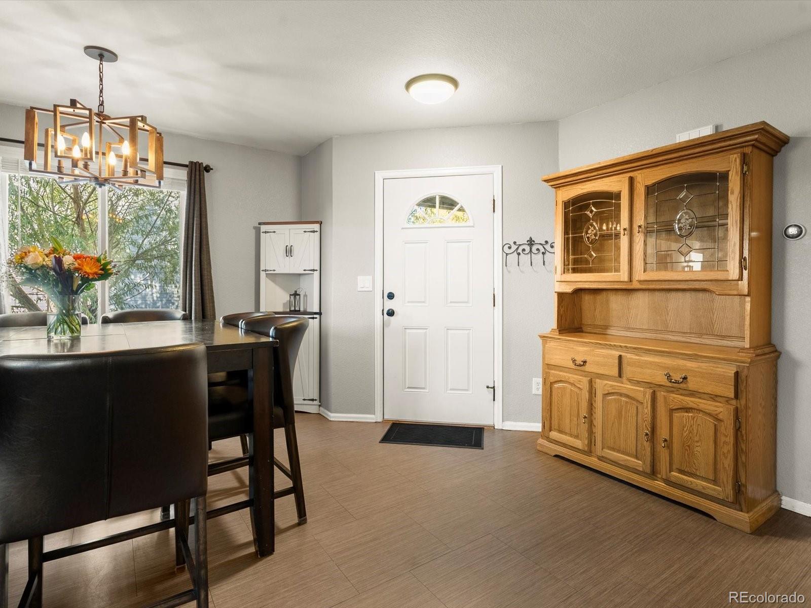 9657 Ironton Street Commerce City, CO 80022 - Photo 6 of 48 a view of a dining room with furniture a livingroom and chandelier