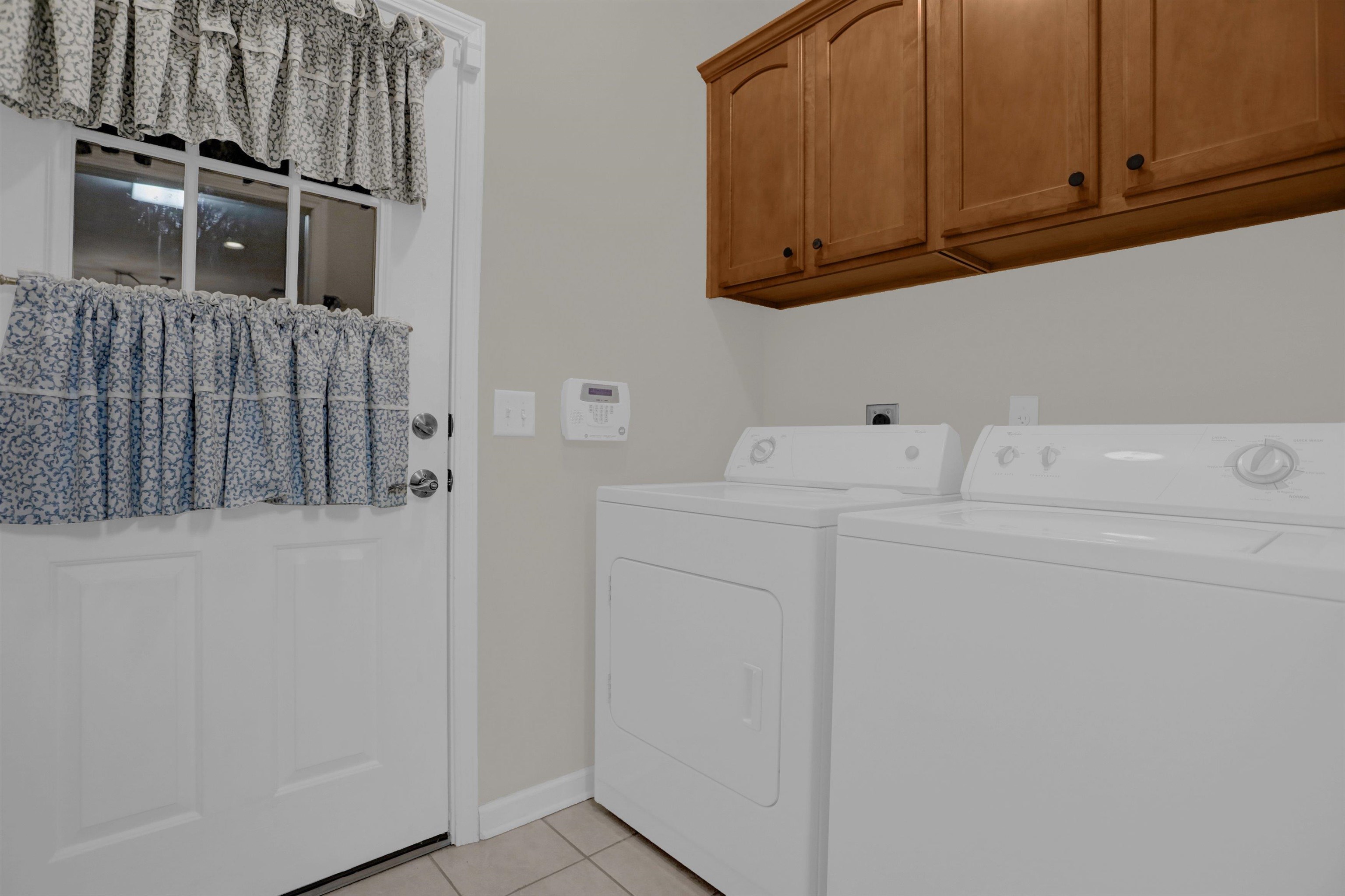 34 Peyton Ridge Drive, Unit 21 Collierville, TN 38017 - Photo 19 of 37 Laundry area with upper wood cabinets, a white door with glass panels, and neutral-toned wall paint