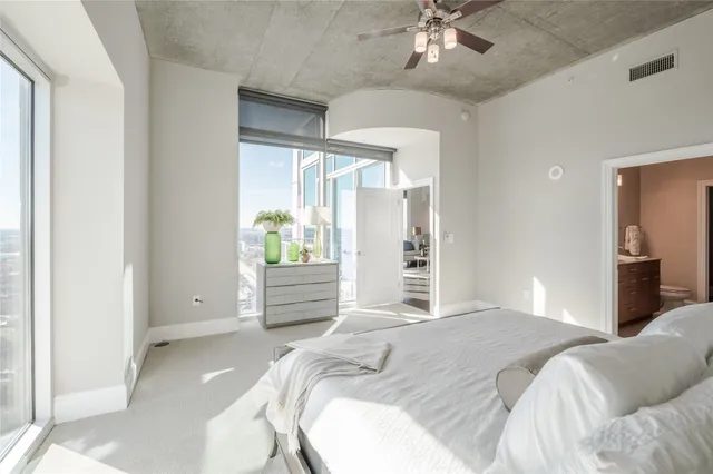 a bedroom with a large bed and a chandelier