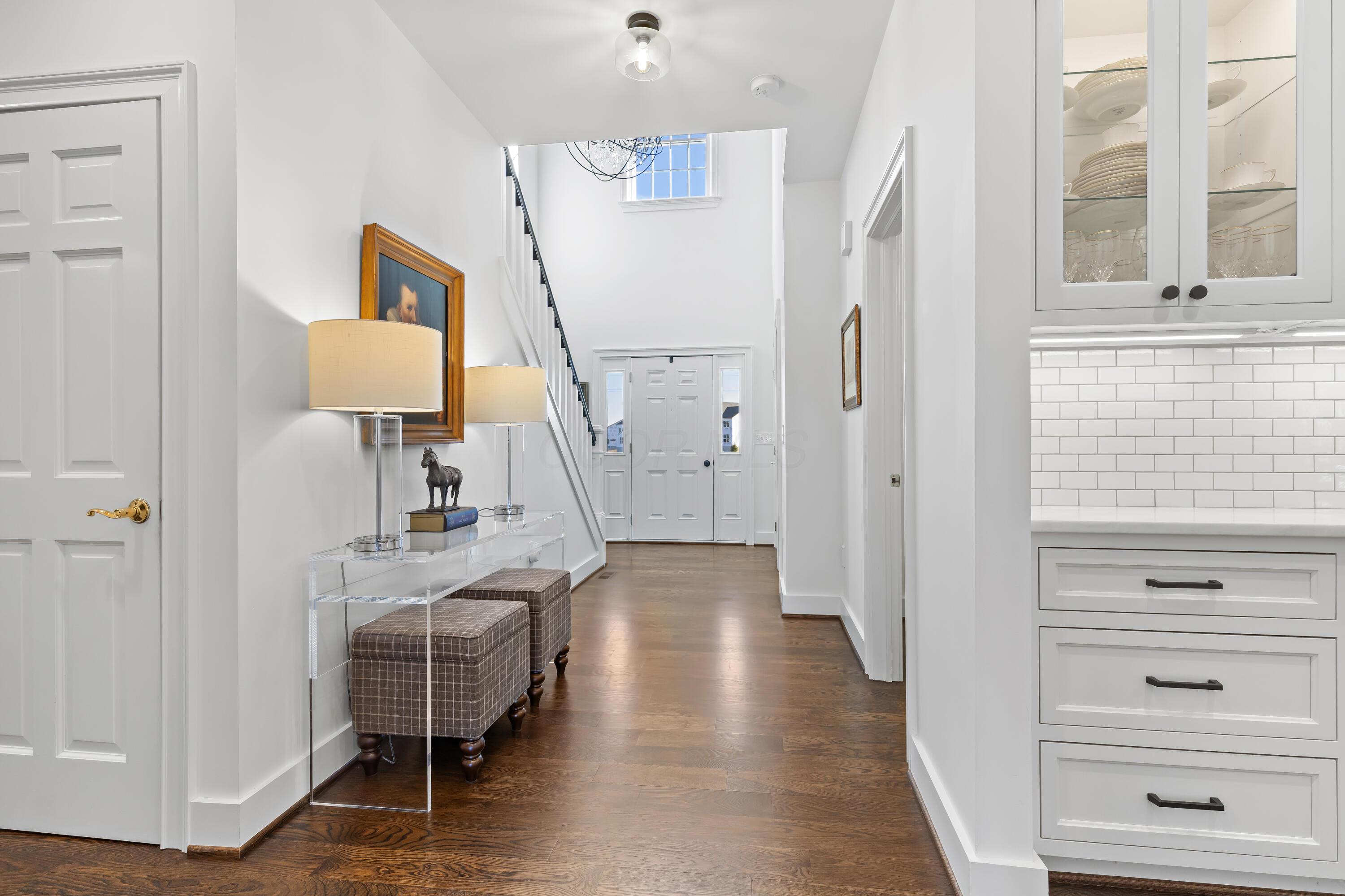 1364 Dale Ford Road Delaware, OH 43015 - Photo 7 of 112 • Hardwood flooring • White painted walls • Two-story ceiling • Coat closet • Chandelier • Sidelights by front door • New staircase