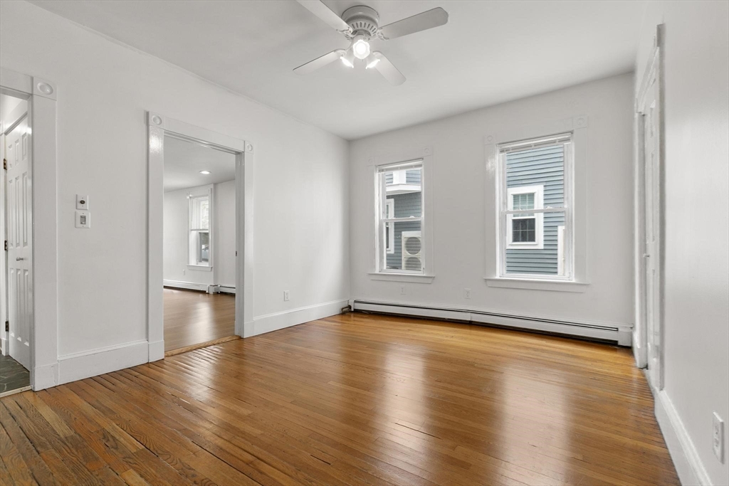 27 Dix Street, Unit 1 Boston, MA 02122 - Photo 4 of 10 an empty room with wooden floor and windows