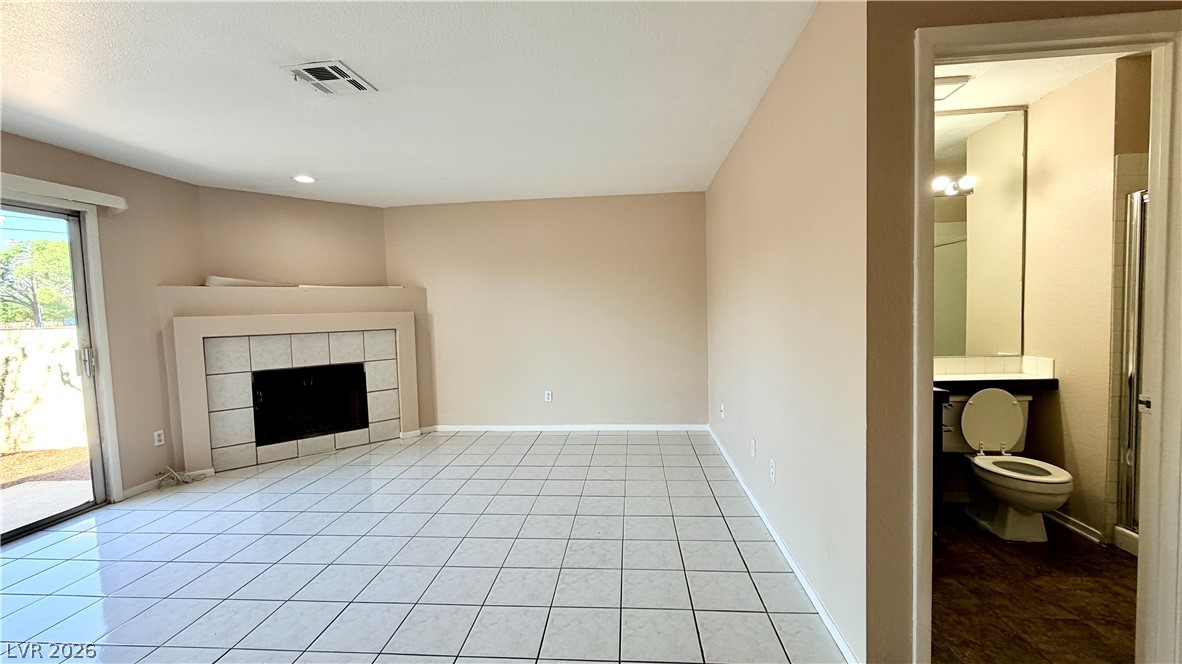 6250 West Flamingo Road, Unit 4 Las Vegas, NV 89103 - Photo 6 of 45 This spacious room features a classic fireplace, gleaming tiled floors, and a bright patio door.