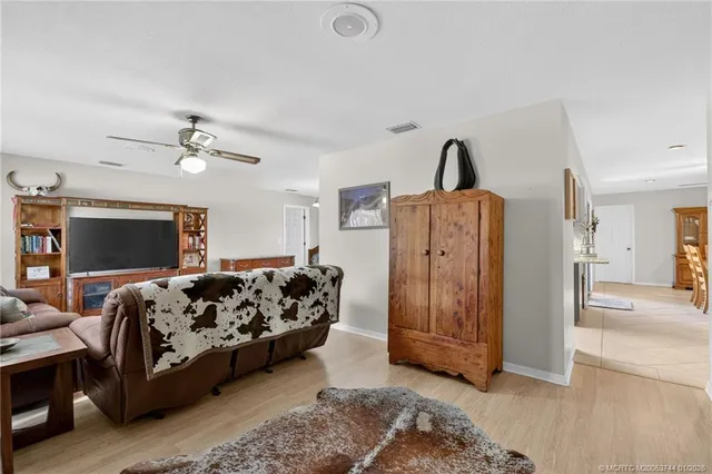 a living room with furniture a flat screen tv and kitchen view