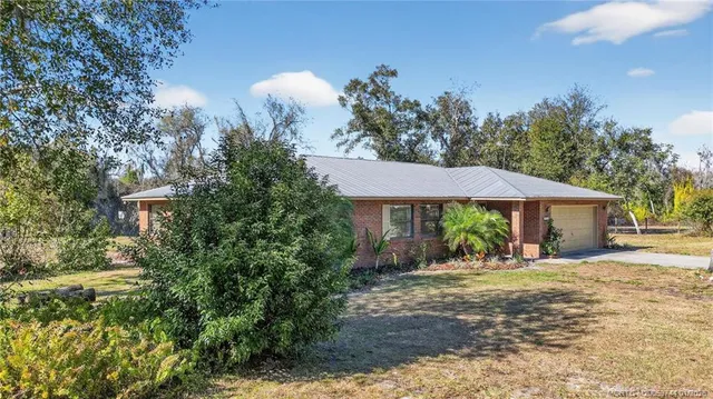 a view of a house with yard and sitting area