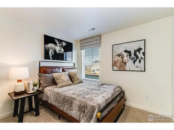a bedroom with a bed and a painting on the wall