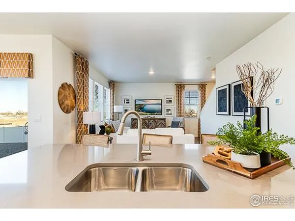 a kitchen with kitchen island granite countertop a sink and a large mirror with potted plant