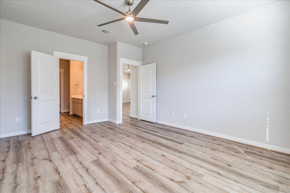 144 Threshing Road, Unit A Buda, TX 78610 - Photo 15 of 35 Primary bedroom located on main level and features a window seat, ceiling fan and LVP flooring.